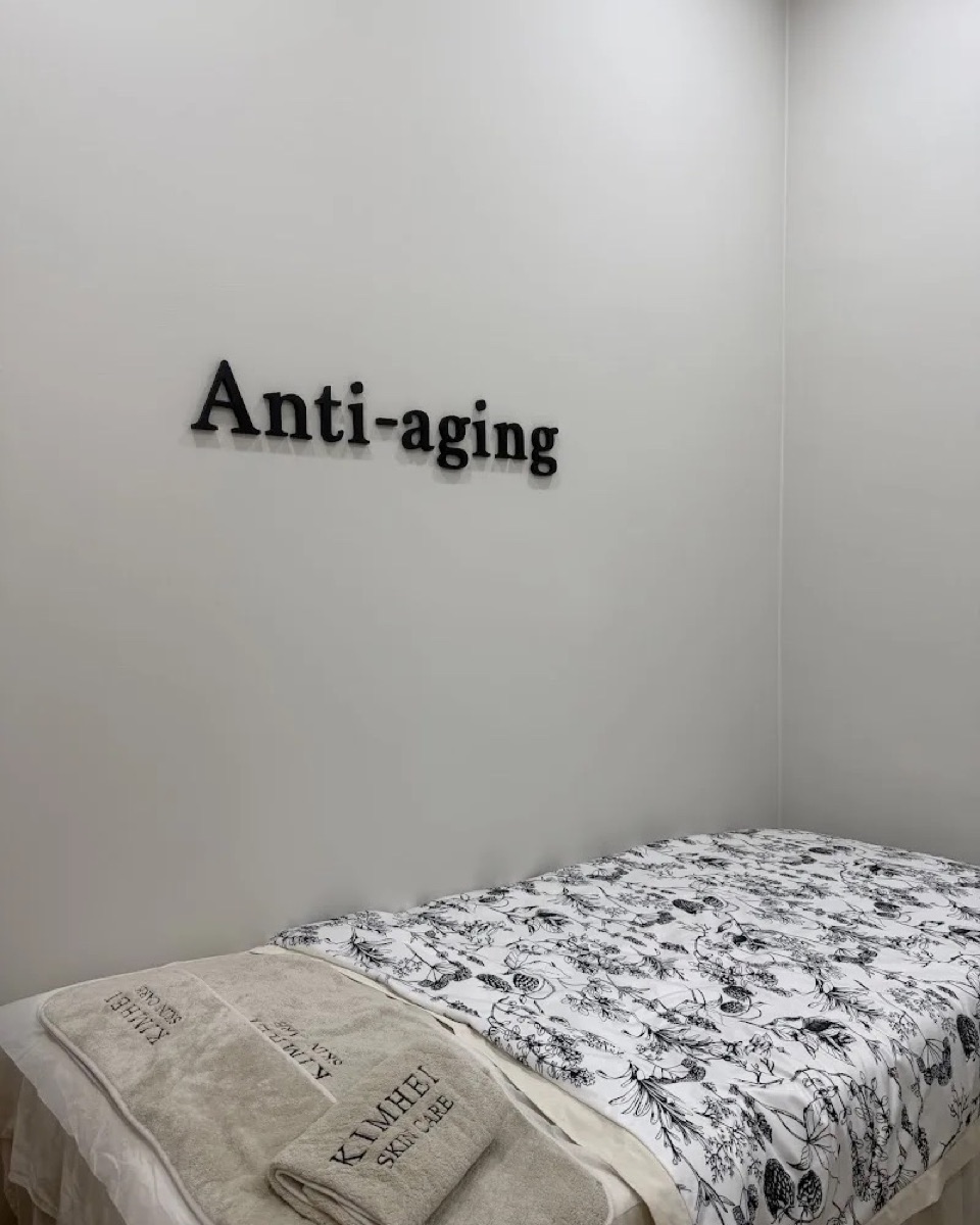 Anti-aging treatment room at KIMHEI with a made-up bed